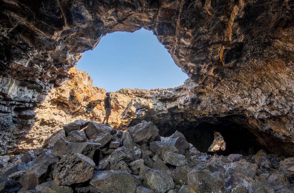 Man looking up to a hole made of rocks